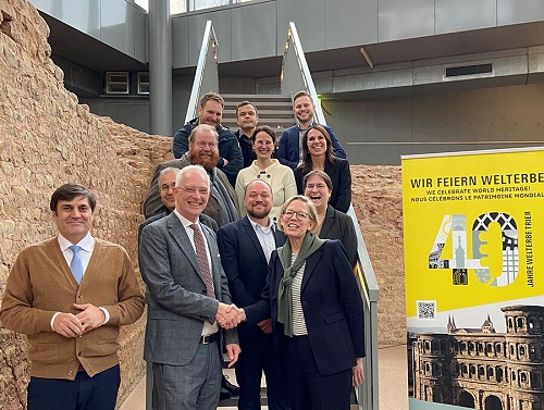 Sie freuen sich auf das bunte Festjahr zum 40. Geburtstag des Welterbes in Trier: Oberbürgermeister Wolfram Leibe (2. v. l.), Staatssekretärin Simone Schneider (rechts), die Chefin der Generaldirektion Kulturelles Erbe Rheinland-Pfalz, Dr. Heike Otto (zweite Reihe, rechts), Kulturdezernent Markus Nöhl (dritte Reihe, links) sowie Verantwortliche, die das Festjahr gestalten. Bildquelle: Presseamt Trier