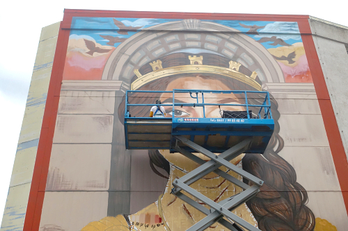 Wandgemälde „The Soul of Trier: Das Werk entsteht seit dem 18. Mai an einer Fassade in der Karl-Marx-Straße, direkt gegenüber der Brücke. Gestaltet wird es von der Künstlerin Sara Lamine aus Metz, die im Rahmen des Projekts QuattroWalls in Trier als Artist in Residence arbeitet. Foto: r3/hb